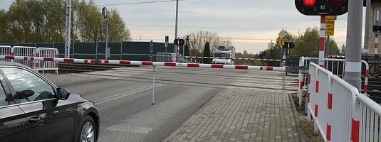Samochód stojący przd zamkniętym szlabanem na przejeździe kolejowo-drogowym Łowicz - Myślaków