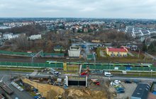 Widok z lotu ptaka na nowe filary wiaduktu drogowego w Pruszkowie. Widać tory kolejowe i pociąg. fot. Ł. Bryłowski