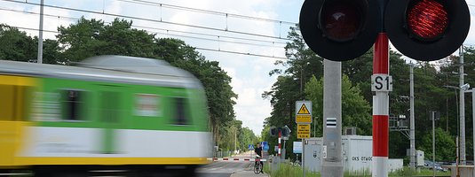 Pociąg w ruchu na przejeździe z zamkniętymi rogatkami
