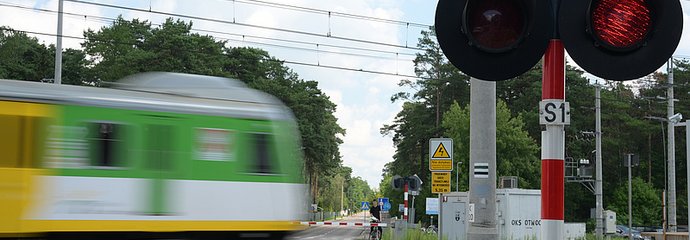 Pociąg w ruchu na przejeździe z zamkniętymi rogatkami