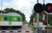 Pociąg w ruchu na przejeździe z zamkniętymi rogatkami