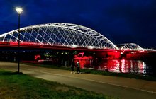 Nowy most kolejowy nad Wisłą w Krakowie, iluminowany w biało-czerwonych barwach, widok z bulwaru, fot. Piotr Hamarnik