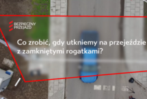 Ujęcie z filmu, widok kamery z góry na samochód, tekst Co zrobić gdy utkniemy na przejeździe. 