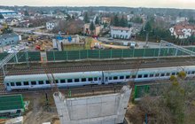 Pociąg jedzie po torach w Pruszkowie, widać filar nowego wiaduktu drogowego, fot. Łukasz Bryłowski (2)