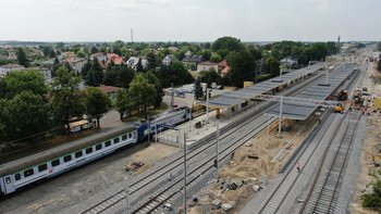 Pociąg przy nowym peronie na stacji w Ożarowie Mazowieckim, widać wykonawców na budowie drugiego peronu i wiaty, fot. A.Lewandowski, P.Mieszkowski