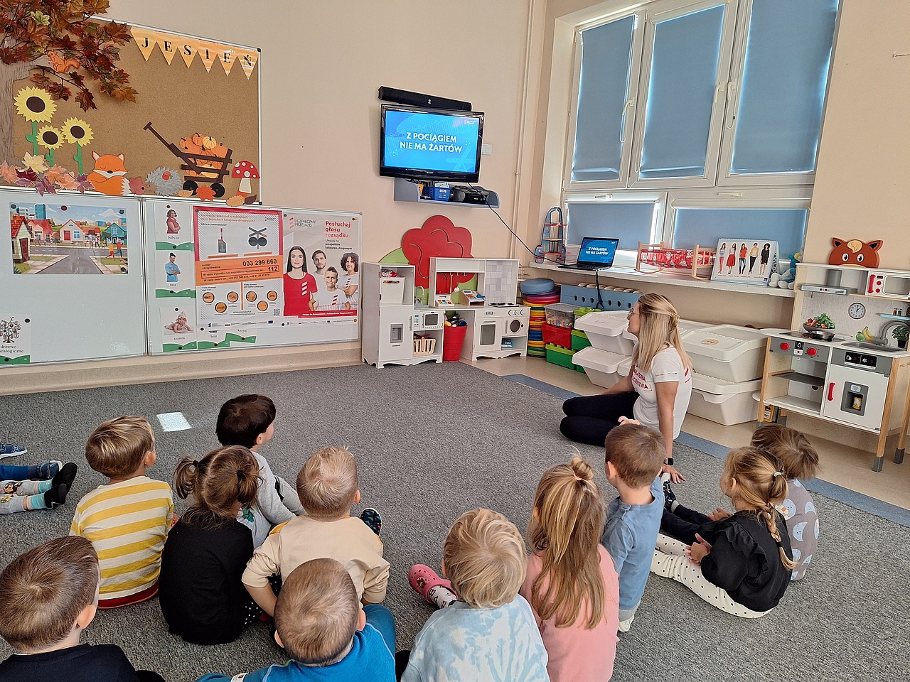 Prelekcja w przedszkolu. Uczestnicy oglądają film edukacyjny.